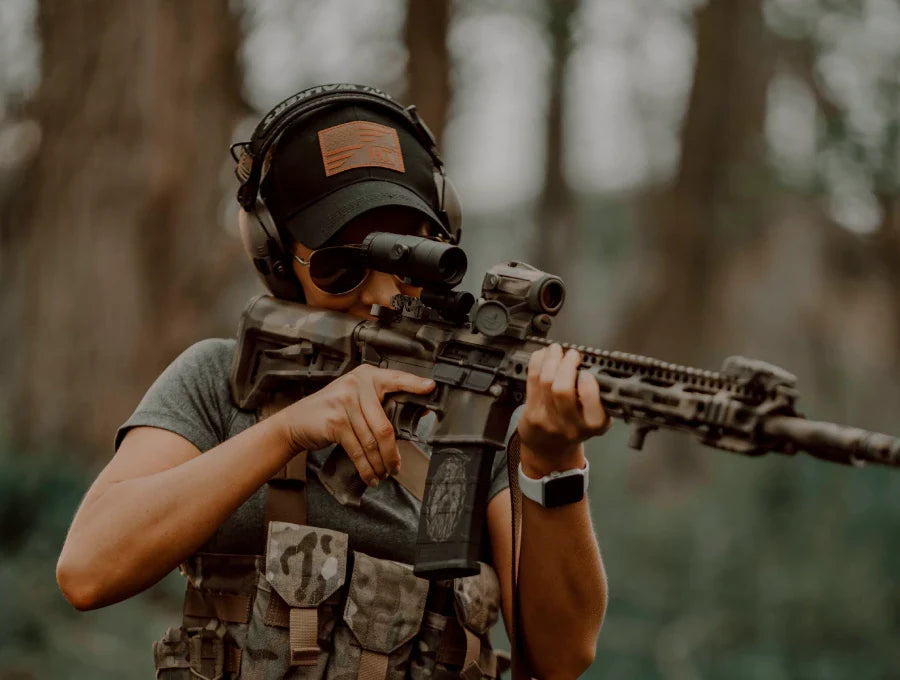 A woman with a gun wearing an American Flag Hat